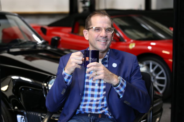 A person holding a mug while sitting