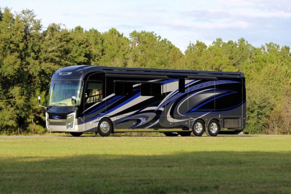 A black and blue bus parked in an open field
