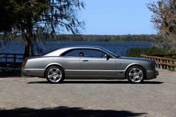 A gray luxury car parked near a lake